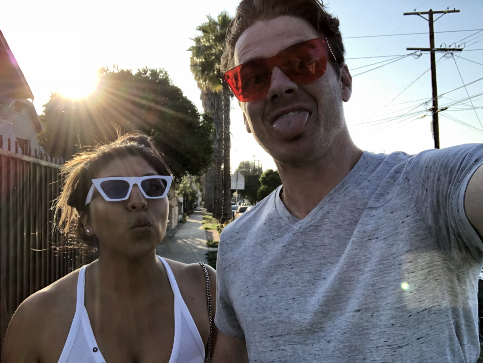 Golden-hour sidewalk selfie with silly faces