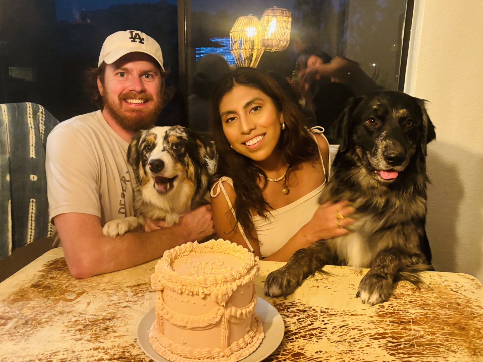 Adriana and Cameron with their two dogs and a birthday cake
